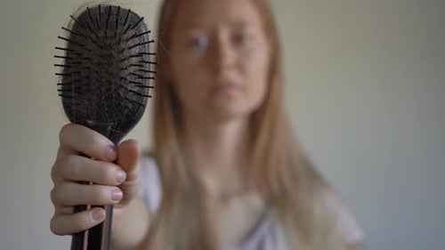 Une jeune femme souffre de perte de cheveux. Concept de perte de cheveux
