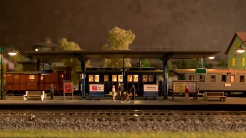 Locomotiva a diesel de brinquedo em movimento pela estação ferroviária modelo.