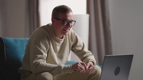 Man Laughing During Pleasant Video Conference at Home