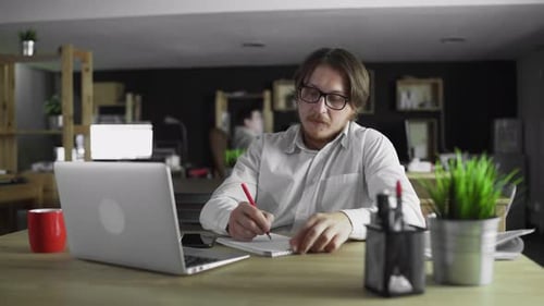 Businessman Is Working in Office Writing Sitting at Desk Alone