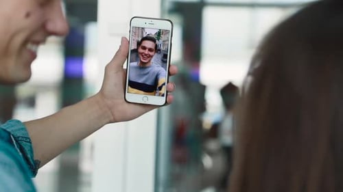 Young Adults Video Calling on Phone in Modern Building