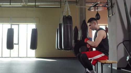 Boxer Wrapping Hands in Gym