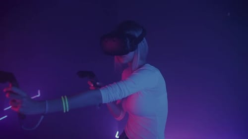 Woman Plays Futuristic Game Wearing VR Headset