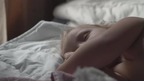 Blond Child Resting in Bed Indoors