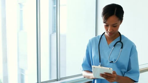 Female doctor using digital tablet in corridor