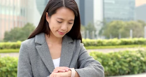 Woman Uses Smart Watch in an Urban Setting