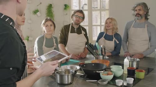 Adults Taking Cooking Class in Bright Kitchen
