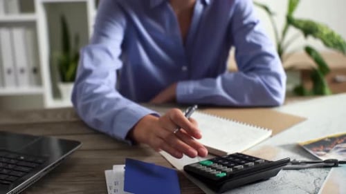 Working On A Calculator, The Manager Counts The Finance Figures While Sitting In The Tourist Office