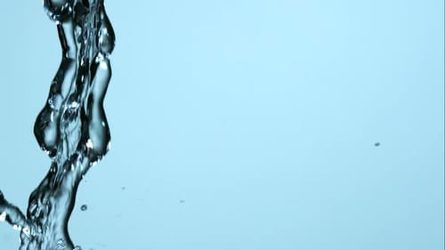 Clear Water Pouring Down Against Light Blue Background