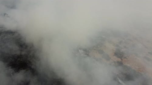 Aerial View of Smoke over a Dark Landscape