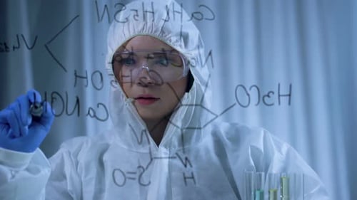 Attractive Female Chemist Writing Complex Chemical Formula on Transparent Board