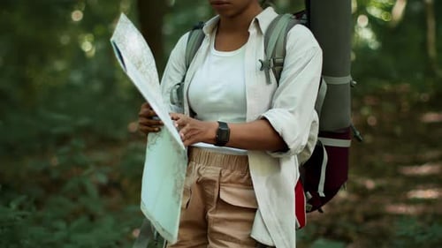 Young Black Woman Taking Paper Map and Studying It Looking for Right Way Got Lost During Hiking Trip