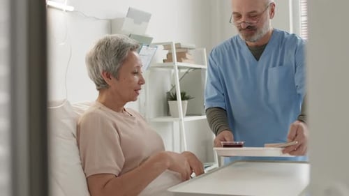 Mature Woman Eating Meal in Hospital Bed