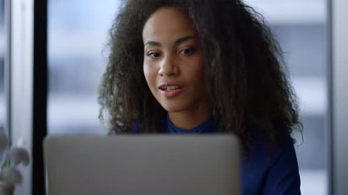 Woman Video Calling Using Laptop Computer in Office