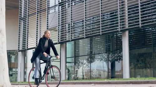 Young woman cycling through city