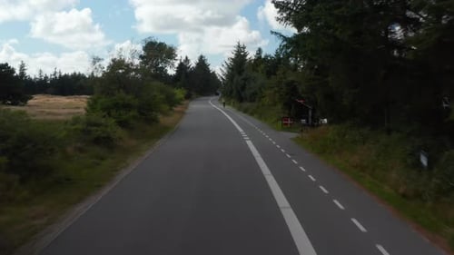 Low Flight Above Road Passing By Cyclist Riding on Cyclist Path