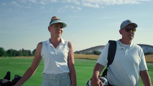 Golf Players Couple Walk Together on Lush Course
