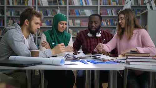 Multiethnische Studierende bereiten sich auf Prüfungen in der Bibliothek vor