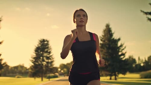 Sport Woman Running at Sunset. Female Runner at Outdoor Workout in Park