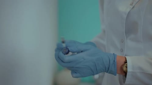 eine Krankenschwester zieht einen Impfstoff zur Injektion in eine Spritze