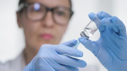 Drawing Clear Liquid into Syringe in Hospital Close Up