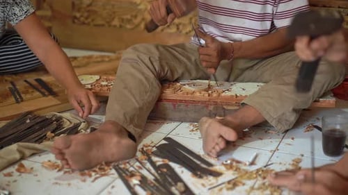 Artisans Carving Intricate Wood Designs in Workshop