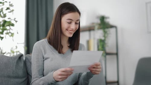 Woman Reading Letter and Smiling with Joy