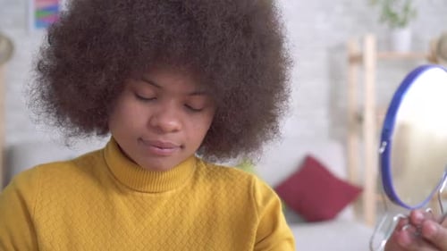 Young Woman Applying Makeup in a Bright Home