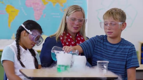 Teacher doing science experiment with students in school classroom