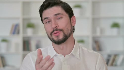 Young Adult Man Talking and Gesturing Indoors