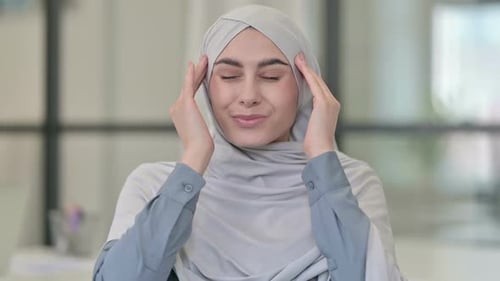 Woman Wearing Headscarf Massaging Temples Due to Headache