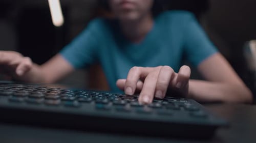Fingers Typing on Black Computer Keyboard at Night