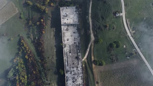 Toma aérea a través de la niebla de un edificio abandonado - 4K