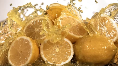 Zeitlupenaufnahme von Zitronensaft, der durch Zitronenscheiben spritzt