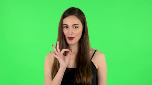 Smiling Woman Gives Okay Sign on Green Screen