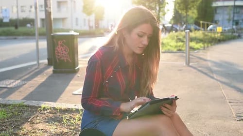 Woman Uses Tablet Outdoors on Sunny Day