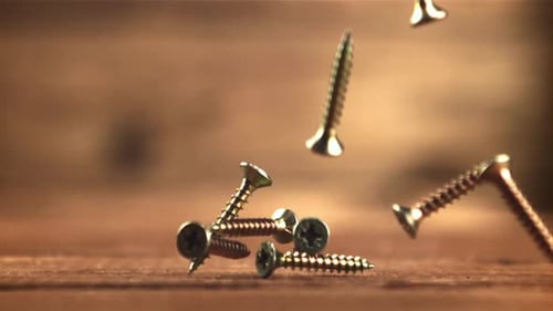 Screws Falling onto Wooden Surface in Slow Motion