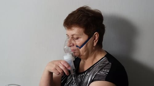 Femme âgée faisant une inhalation avec un nébuliseur