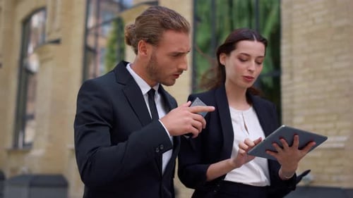 Business Colleagues Using Tablet Together Outdoors
