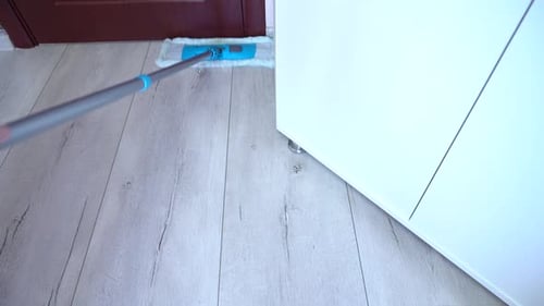 Cleaning Wood Floor with Blue Mop in Home