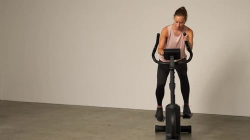 Woman Working Out on Stationary Bike Indoors