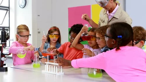 School teacher assisting school kids in chemical experiment in laboratory