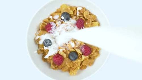 Milk Pouring onto Cereal with Berries
