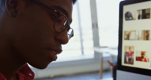 Seitenansicht eines afroamerikanischen Grafikdesigners, der am Schreibtisch im Büro arbeitet 4k