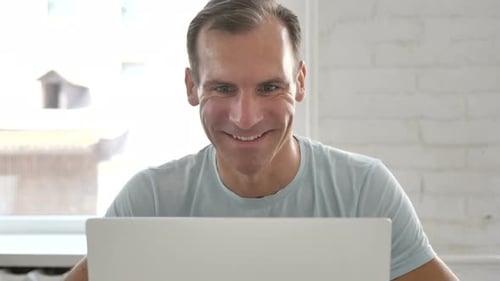 Man Waving During Video Call On Laptop