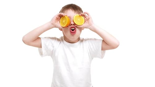 Boy Posing With Orange Slices on White Background