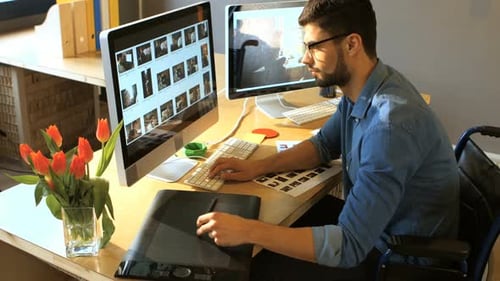 Man in Wheelchair Working at Computer Desk