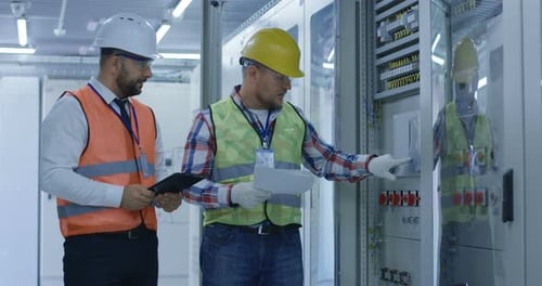 Engineers Working with Electrical Equipment on Station