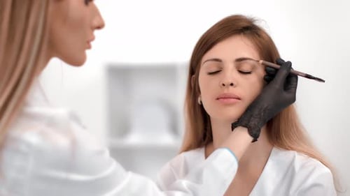 Woman Having Her Eyebrows Shaped in Beauty Salon