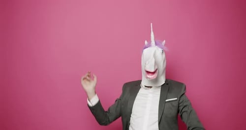 Mann mit Einhornmaske macht lustige Gesten